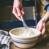 Whisking together mayonnaise dressing in a bowl.