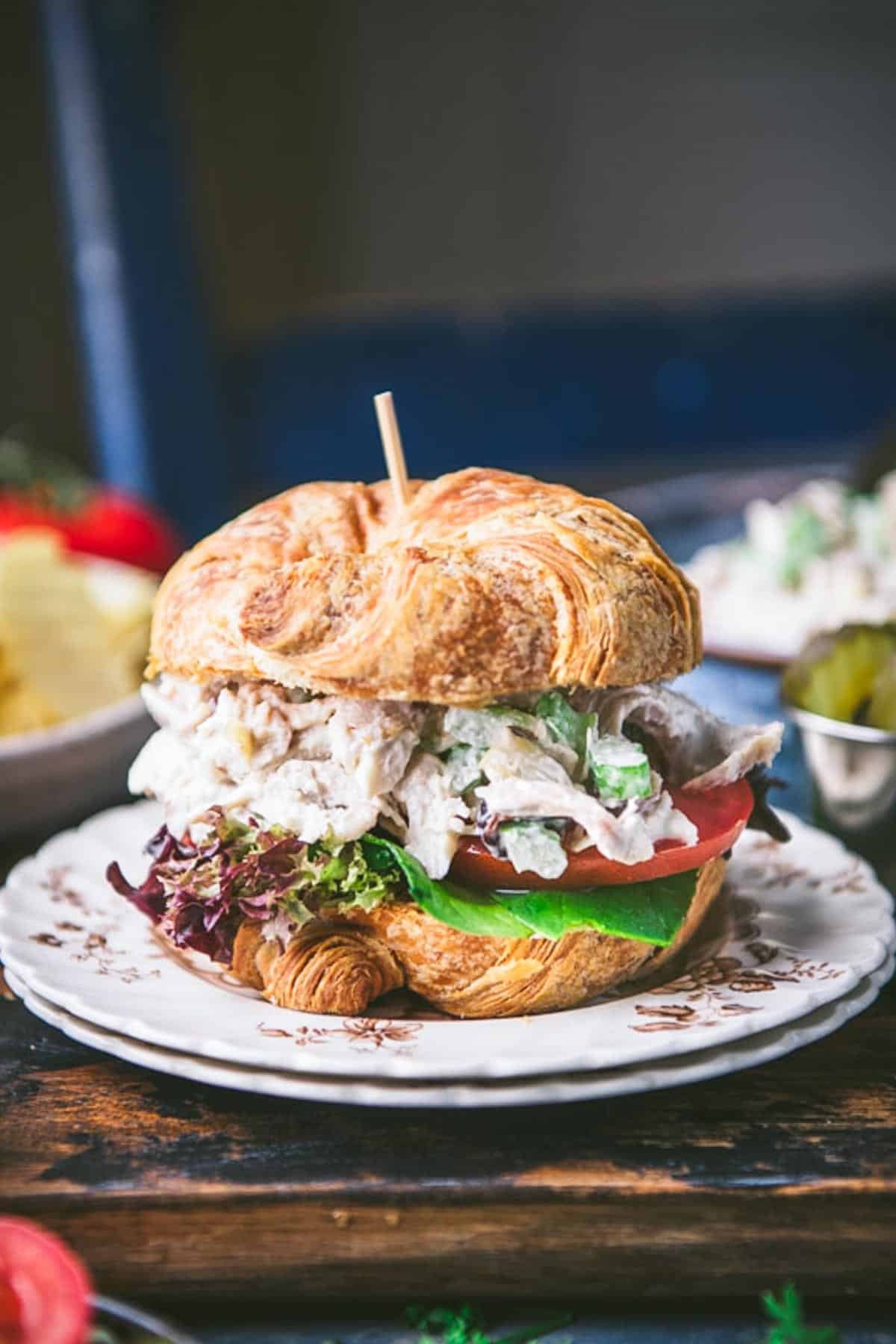 Side shot of a southern chicken salad recipe served in a sandwich on a croissant.