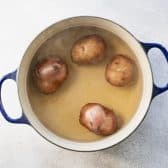 Boiling red potatoes in a Dutch oven.