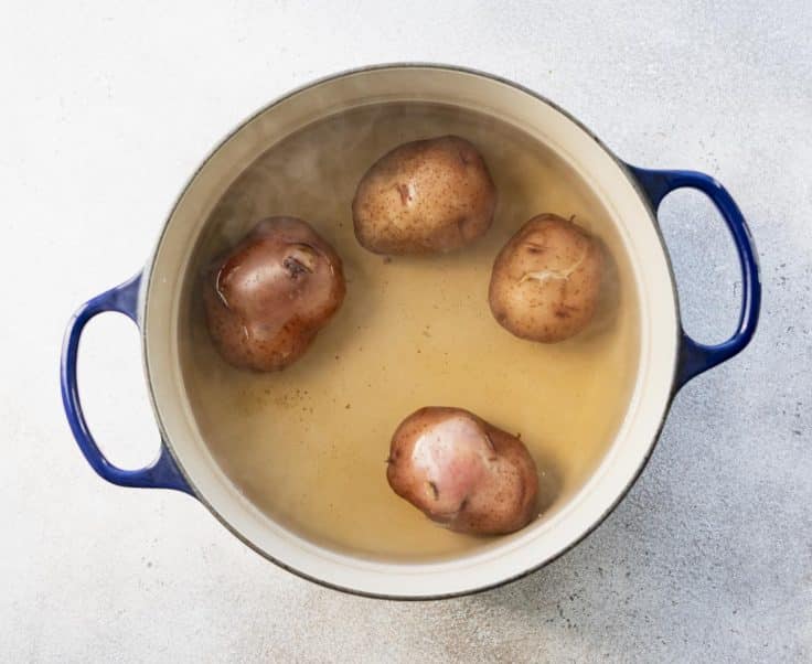 Boiling red potatoes in a Dutch oven.
