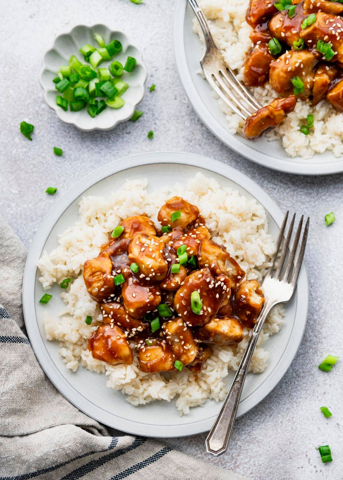 Two plates of rice topped with an easy sticky chicken recipe.