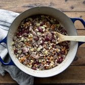 Process shot showing how to make grandma's cowboy calico beans recipe in a dutch oven.