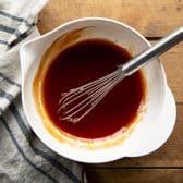 Whisking together sauce for calico beans.