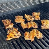 Marinated chicken thighs on the grill.