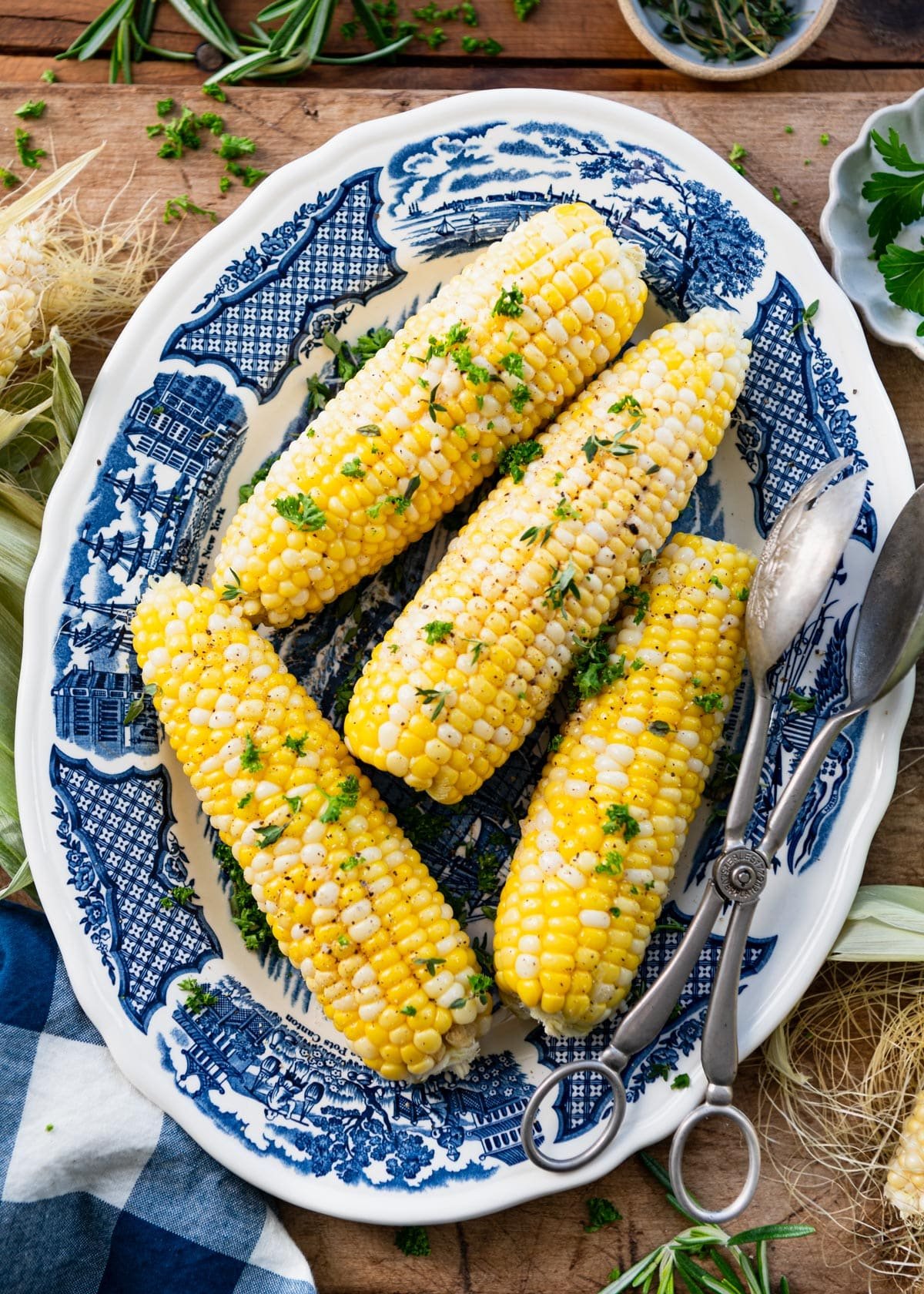 Blue and white plate full of oven roasted corn on the cob.