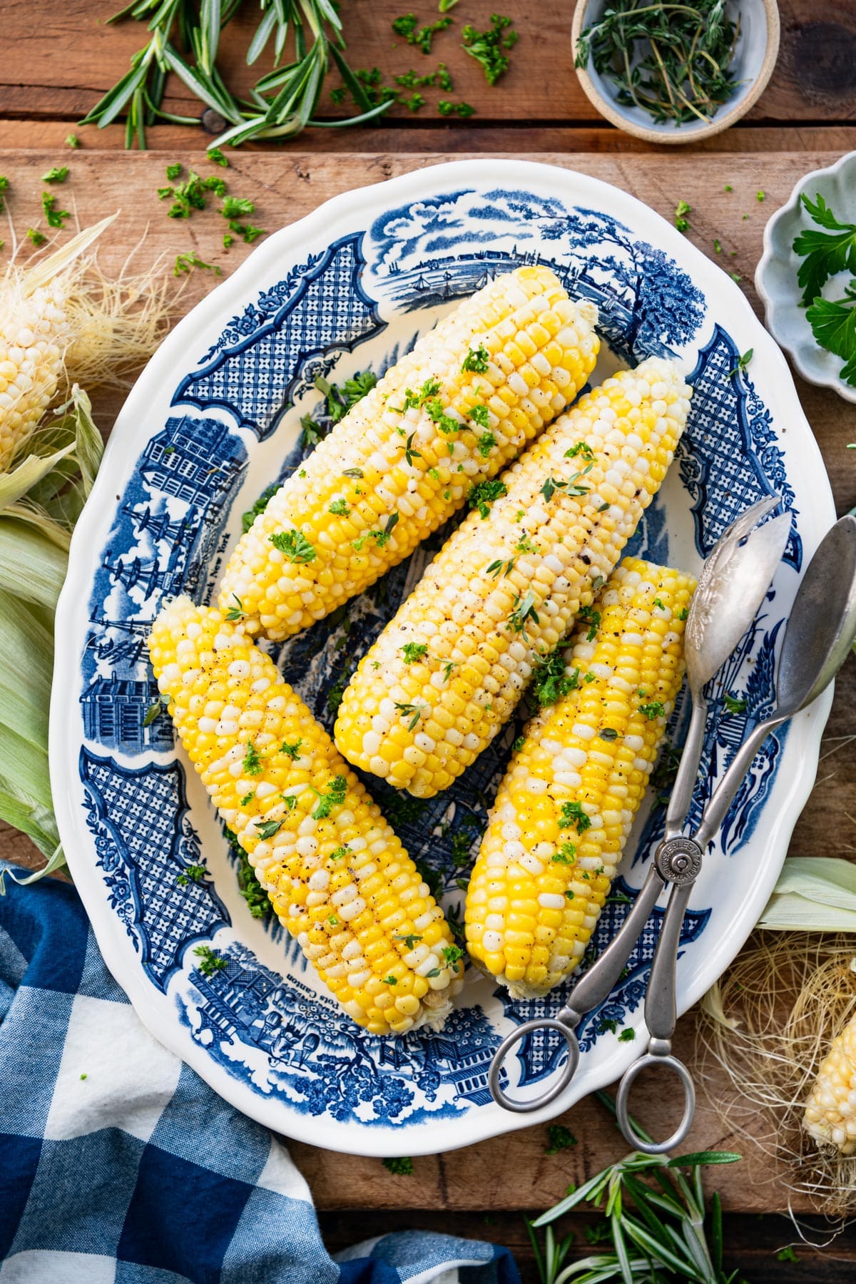 Overhead shot of a blue and white vintage plate with corn on the cob in the oven.