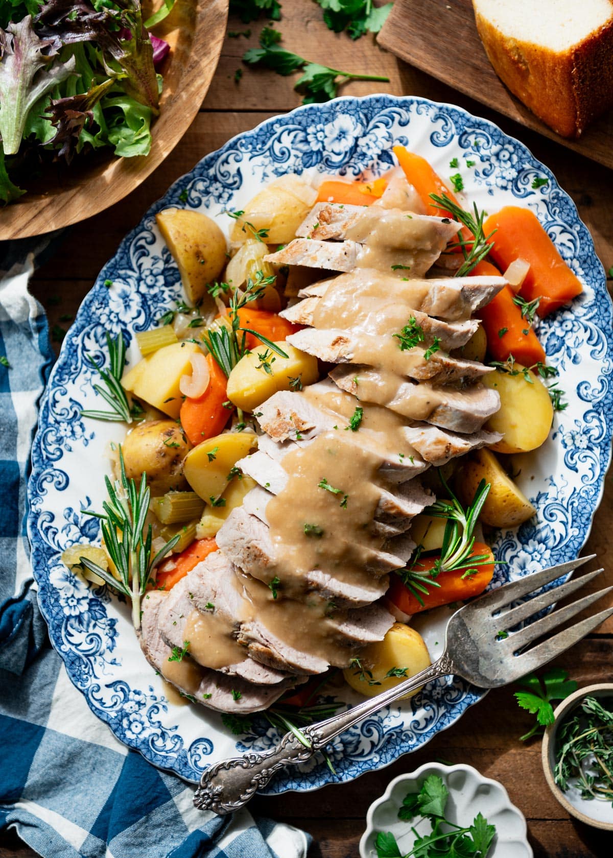 Overhead image of a serving platter full of Dutch oven pork tenderloin with vegetables and gravy.