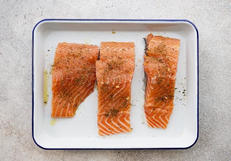 Salmon fillets with olive oil and seasoning before grilling.