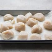 Uncooked scallops on a tray.