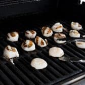 Process shot showing how to cook scallops on the grill.