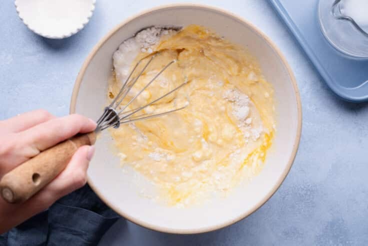 Whisking a bowl of cornbread pancake batter.