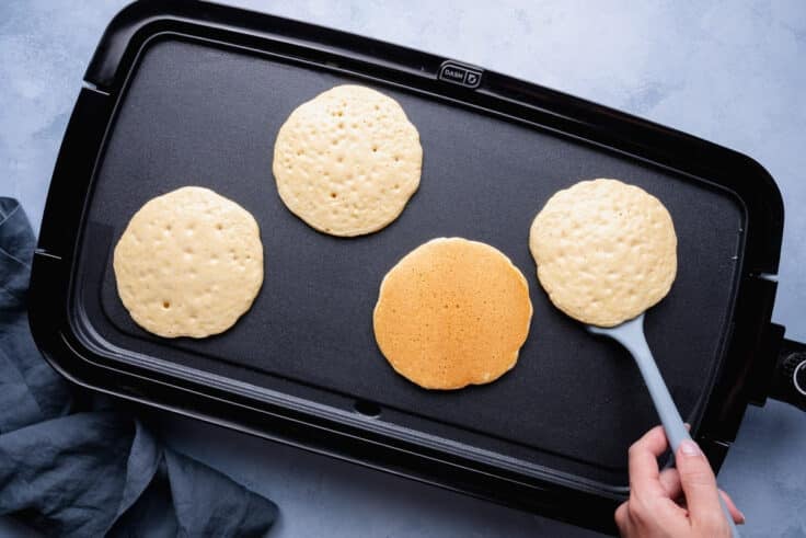 Overhead shot of cornbread pancakes on a griddle.