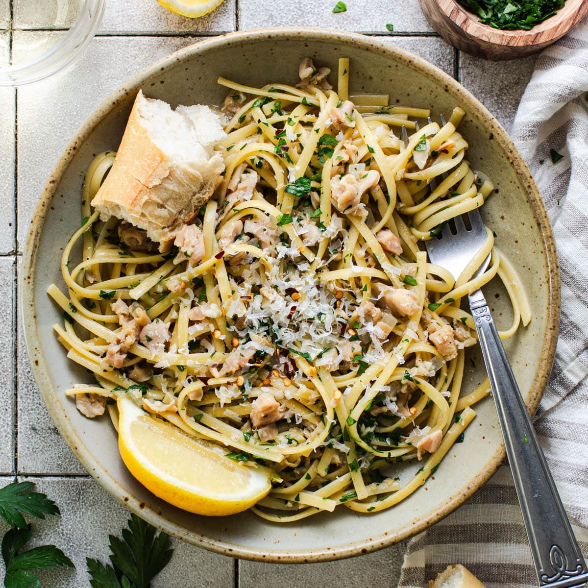 Square overhead shot of a bowl of linguine with clam sauce.