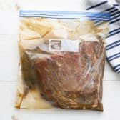 Marinating flank steak in a Ziploc bag.