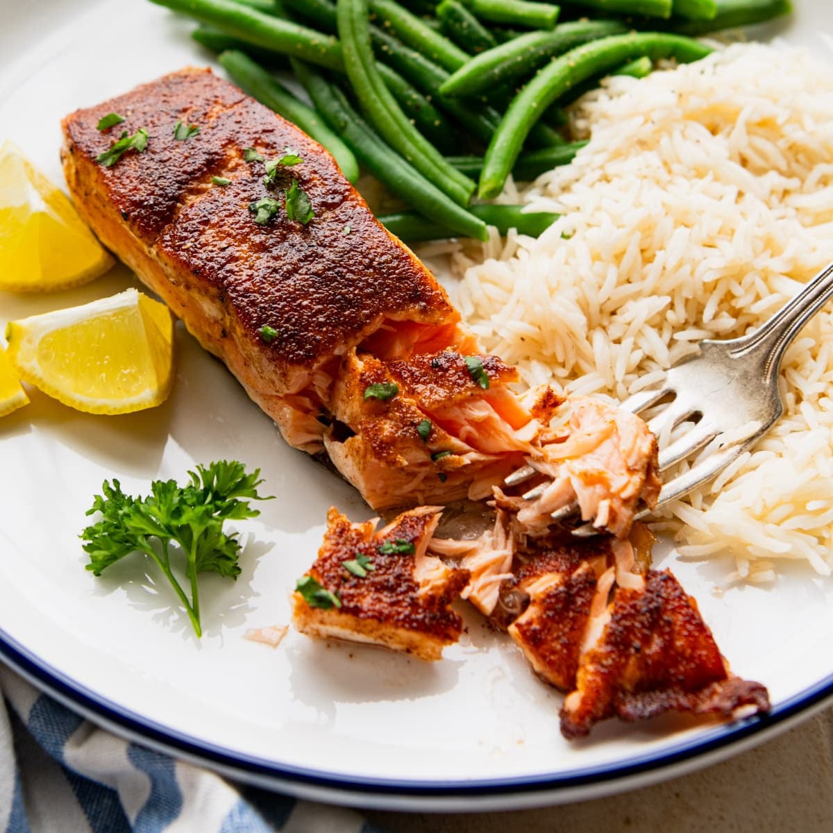 Square side shot of blackened salmon fillet on a dinner plate.