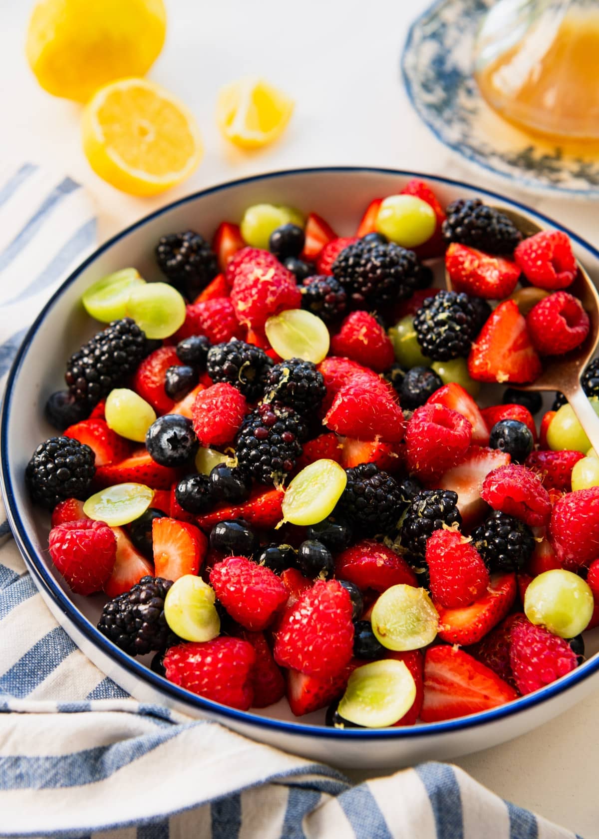 Honey lemon fruit salad dressing on a bowl of fresh fruit salad.