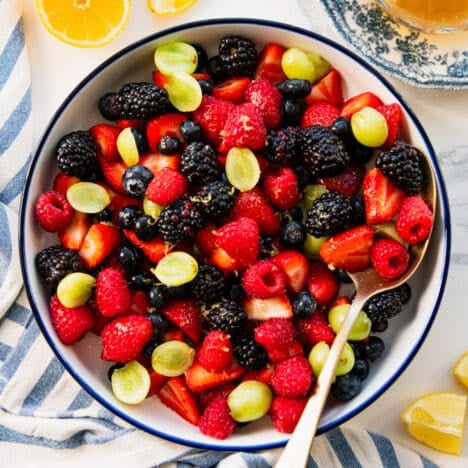 Square overhead shot of fresh fruit salad dressed in a honey lemon fruit salad dressing.