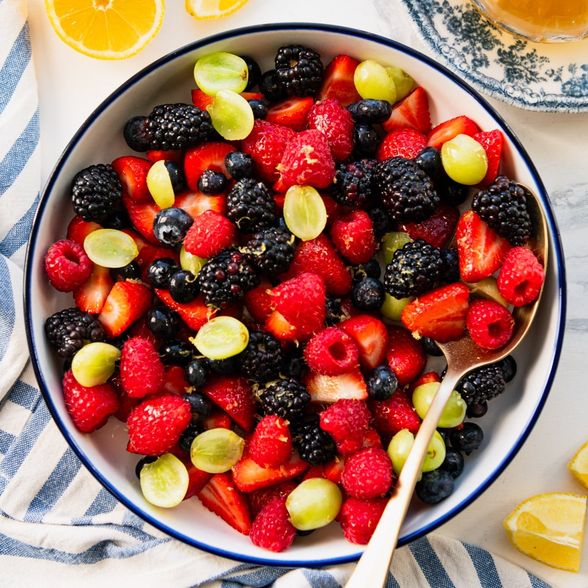 Square overhead shot of fresh fruit salad dressed in a honey lemon fruit salad dressing.