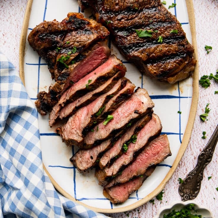 Square overhead shot of grilled marinated steaks.