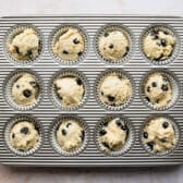 Sour cream blueberry muffin batter in a muffin tin.