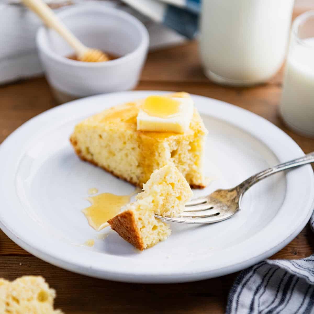 Square side shot of a slice of southern cornbread on a plate.