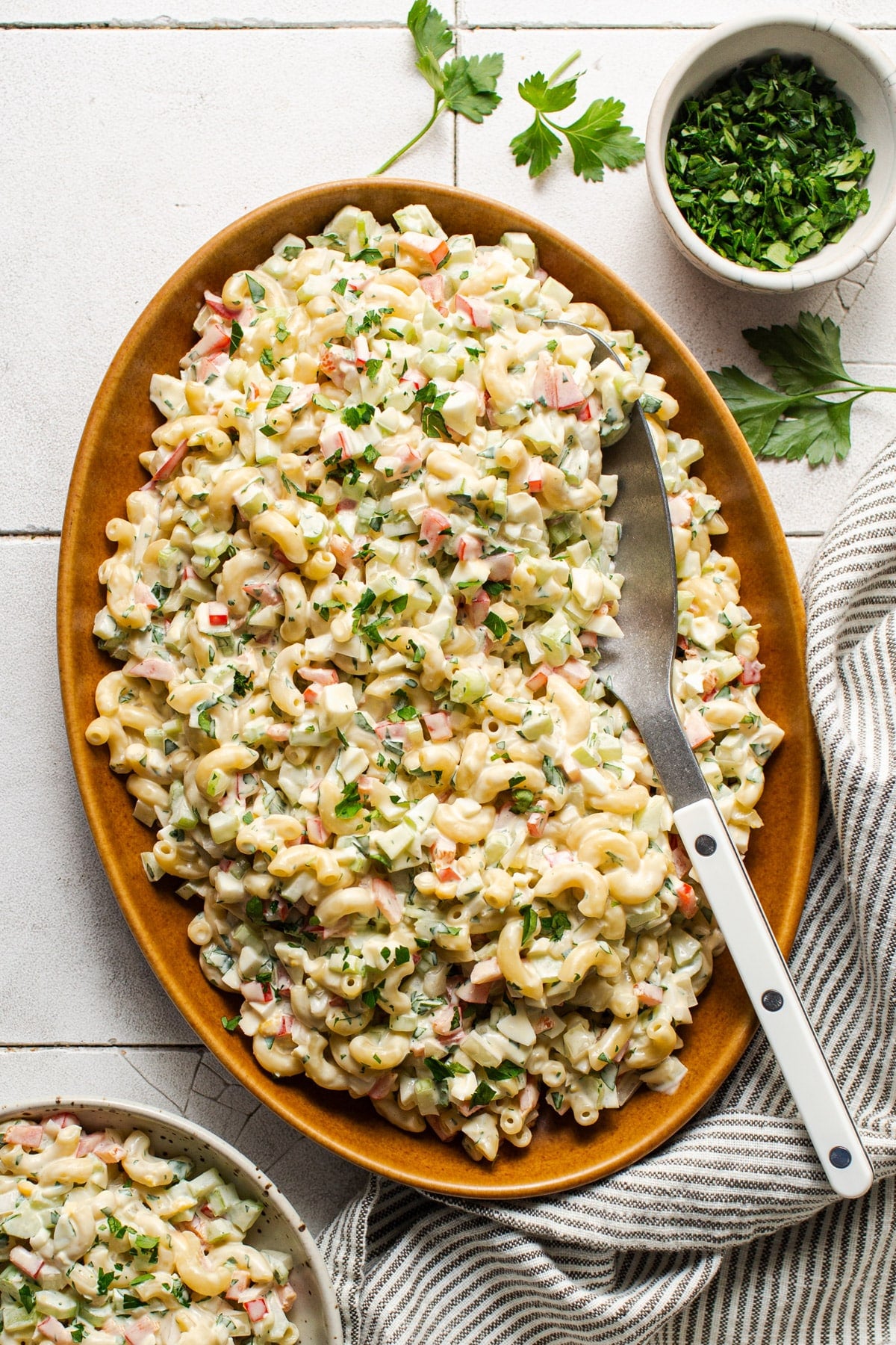 Southern macaroni salad in a wooden serving bowl on a white table.