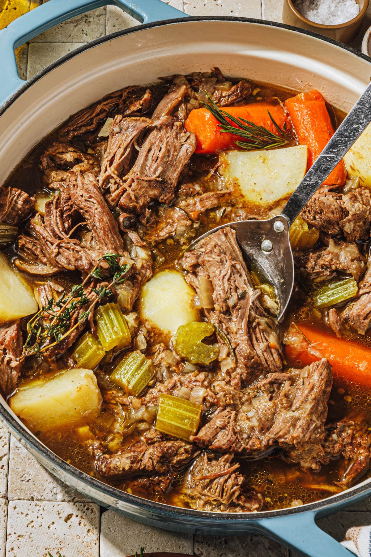 Shredded beef pot roast in a Dutch oven.
