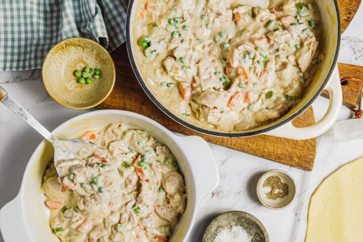 Process shot showing how to assemble a chicken pot pie with pie crust.