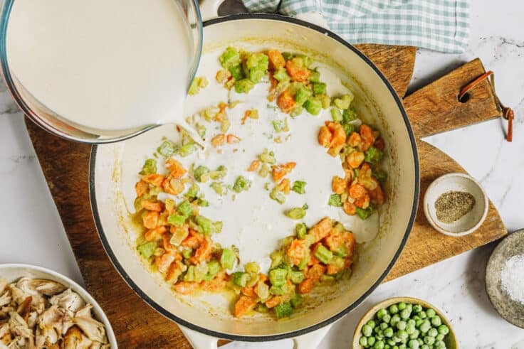 Adding the milk to make the chicken pot pie filling.