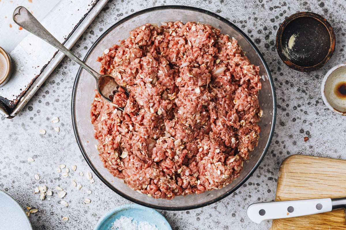 Process shot showing how to mix meatloaf with oatmeal.
