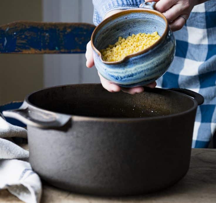 Adding ditalini to a pot of soup.