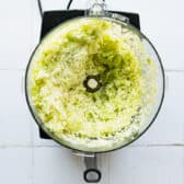 Shredding green cabbage in a food processor.