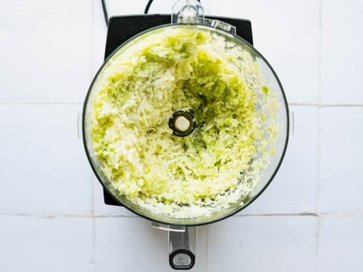 Shredding green cabbage in a food processor.