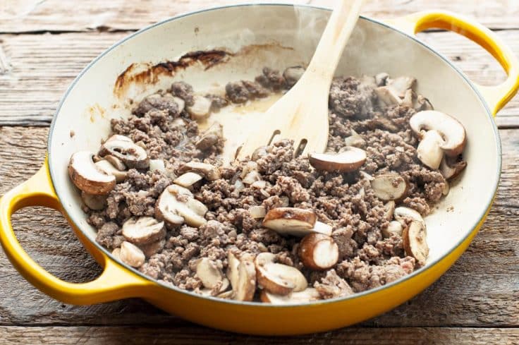 Ground beef and mushrooms in a skillet.