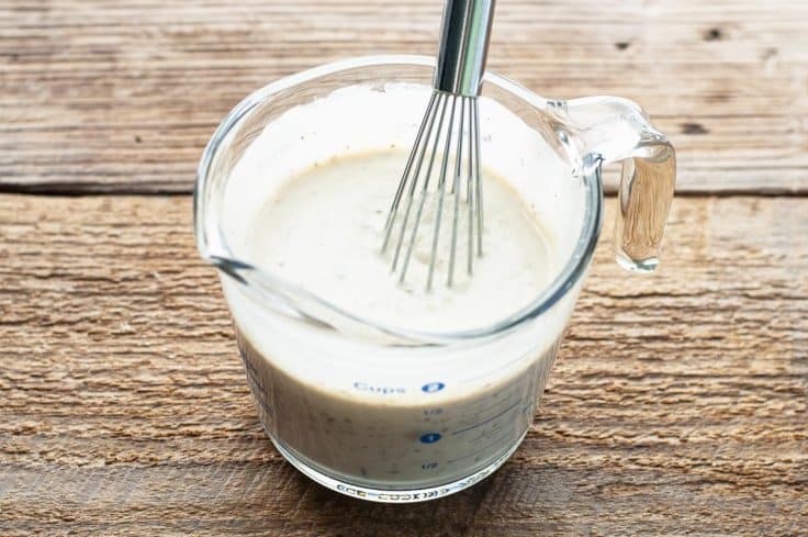 Whisking together cream of mushroom sauce for ground beef stroganoff casserole.