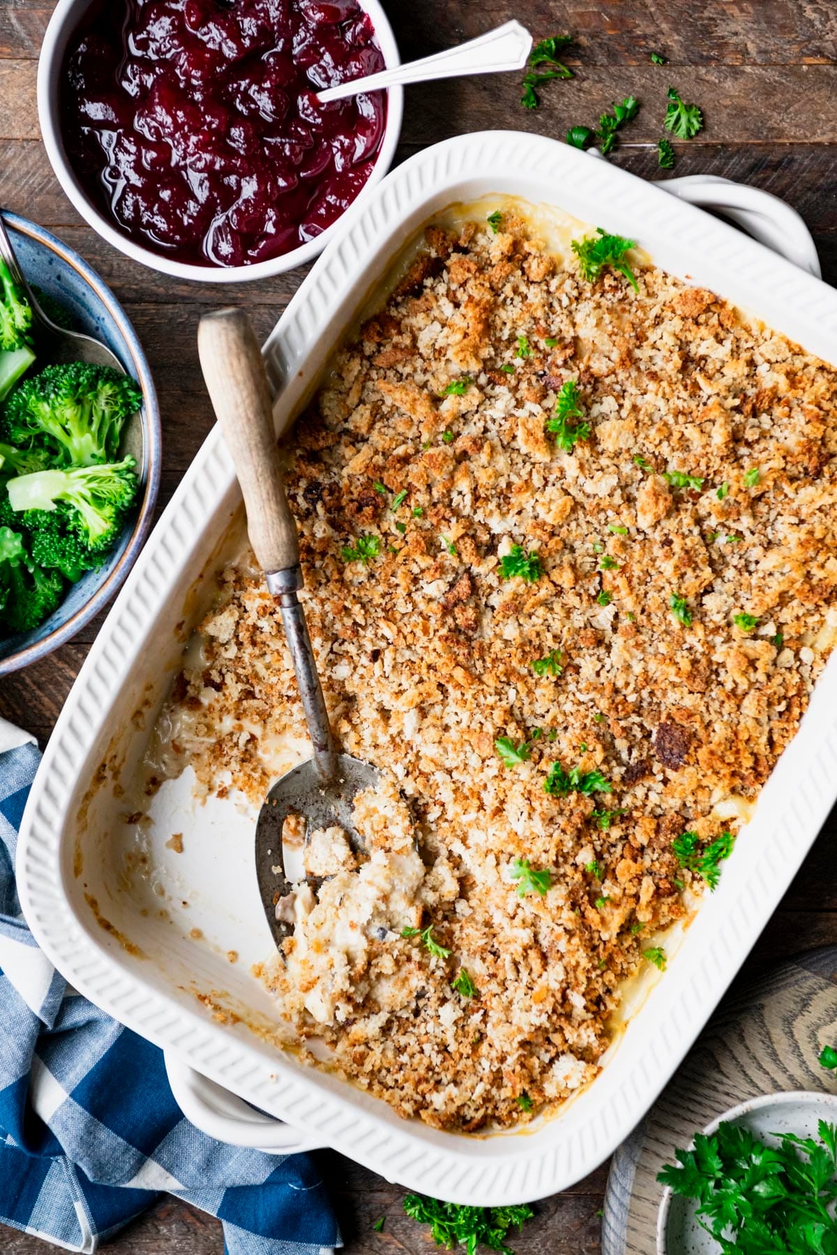 Overhead shot of a dish of old fashioned chicken and stuffing casserole on a wooden table.