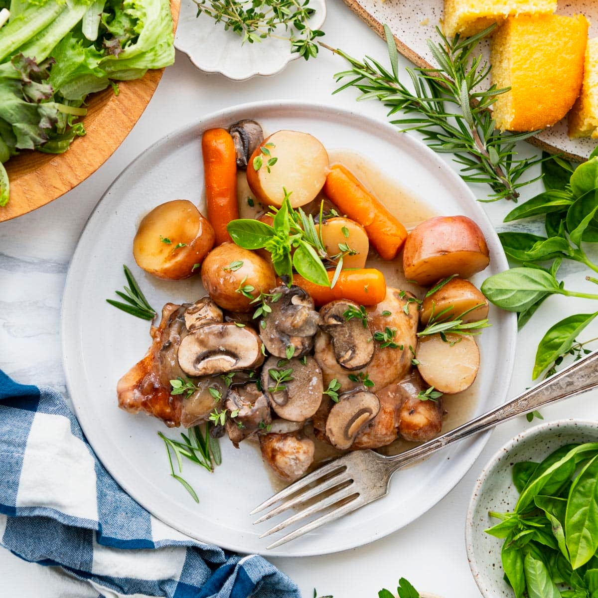 Square overhead image of slow cooker chicken and potatoes on a white plate.