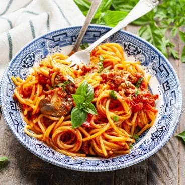 Square side shot of crockpot spaghetti in a blue and white bowl.