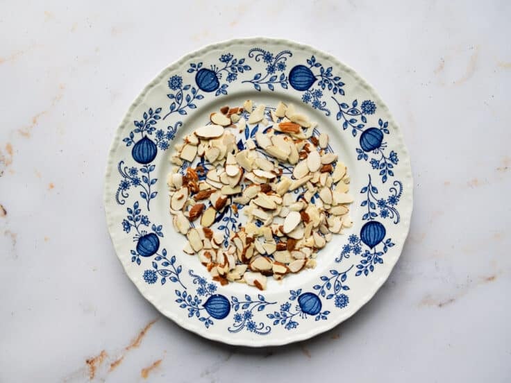 Toasted slivered almonds on a plate.