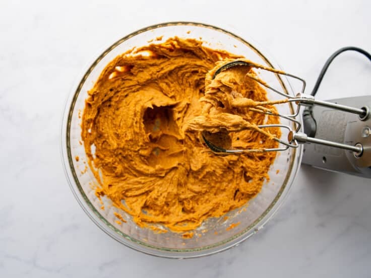 Using an electric mixer to combine the pumpkin and cake mix.