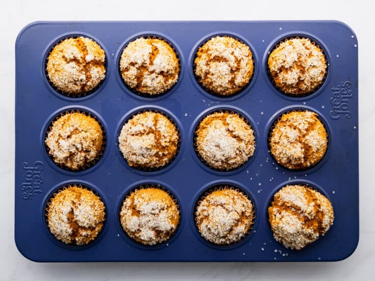 Horizontal overhead shot of baked pumpkin muffins with cake mix in a blue muffin tin.