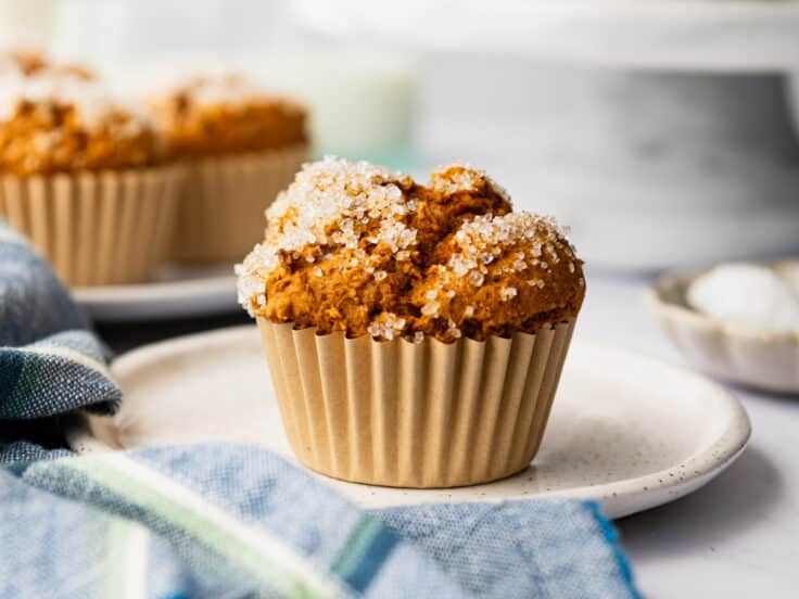 Horizontal side shot of a 2 ingredient pumpkin muffin with cake mix on a white plate.