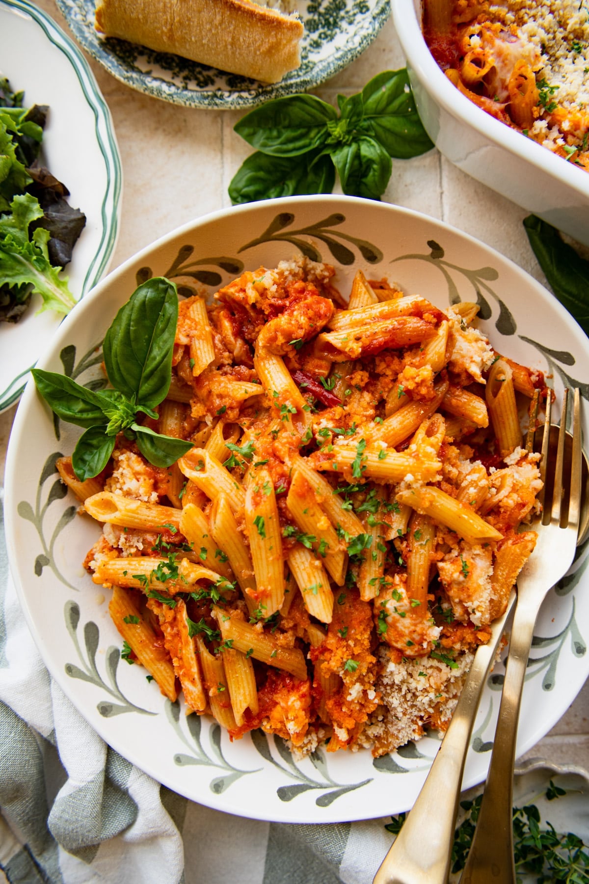 Overhead shot of a fork in a bowl of chicken parm casserole with a fresh basil garnish.