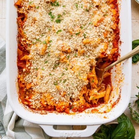Square overhead shot of a chicken parmesan casserole in a white baking dish.