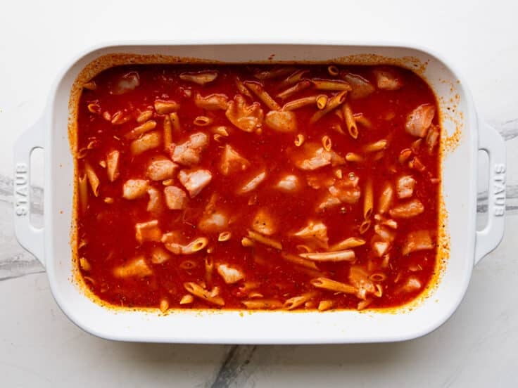 Adding the pasta and chicken to the sauce.
