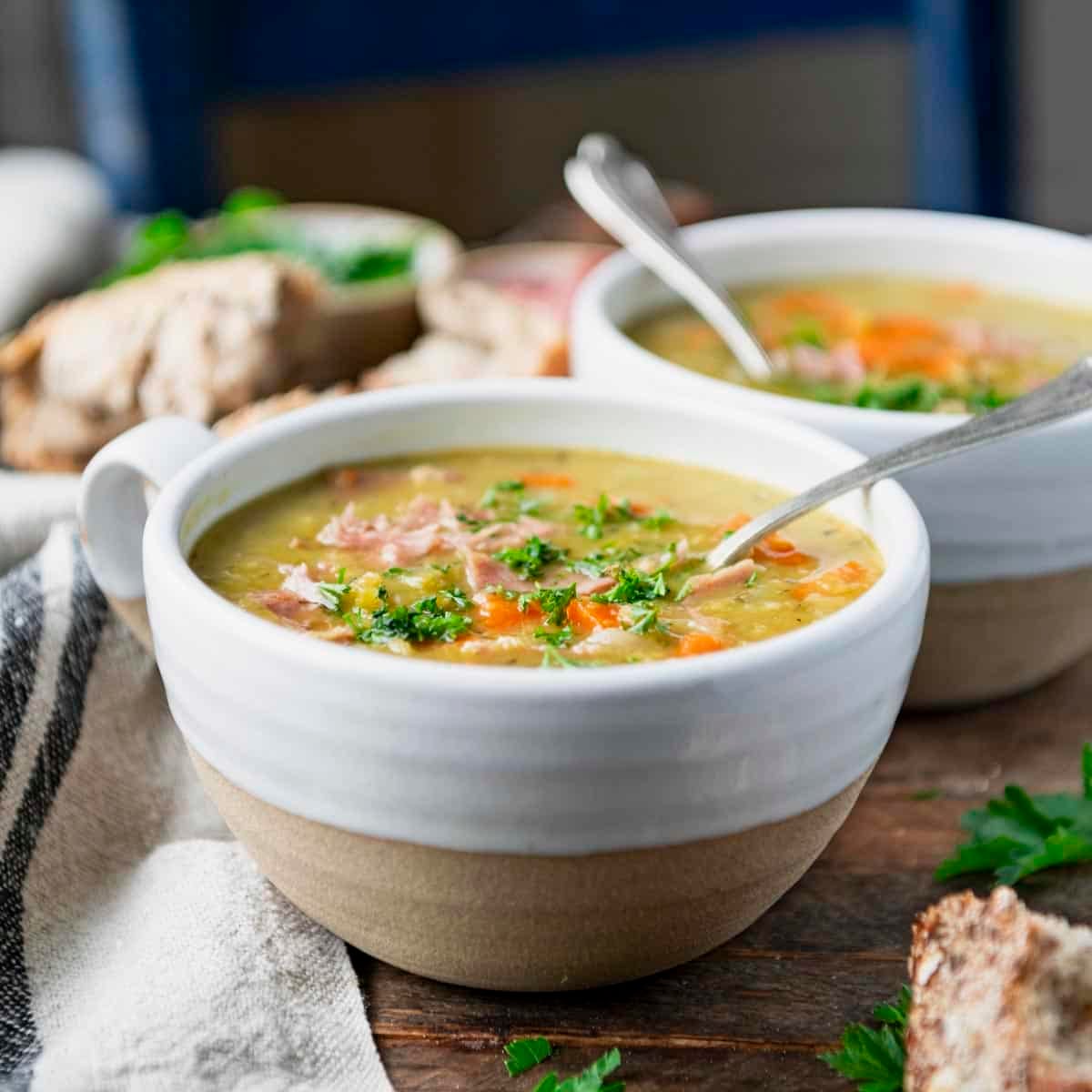 Square front shot of two bowls of split pea soup.