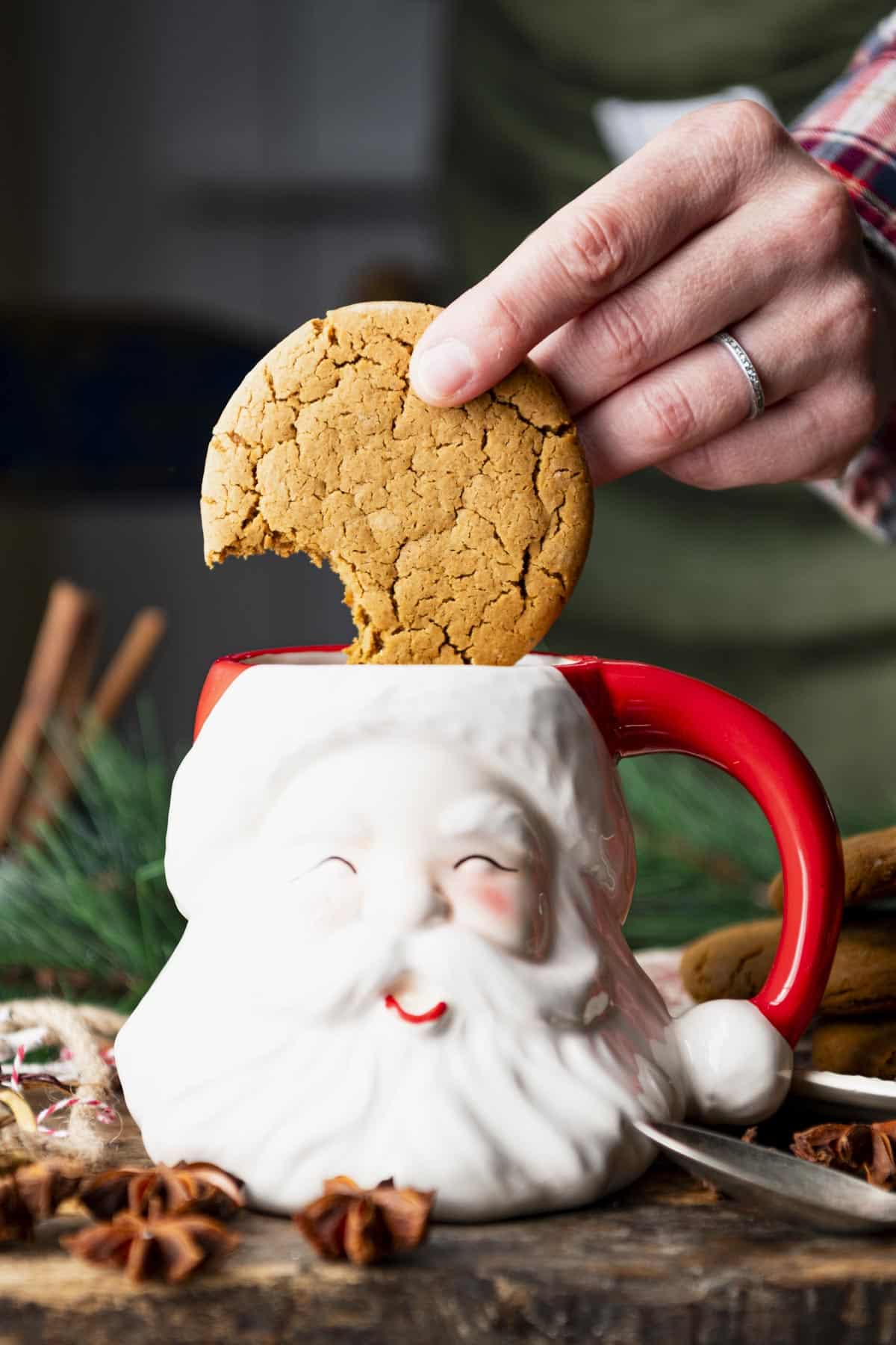Hand dunking soft ginger spice cookies in a mug of cider.