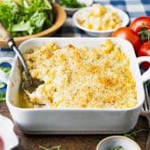 Square side shot of homemade mac and cheese in a square baking dish with garlic breadcrumbs on top.
