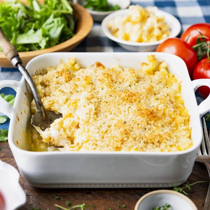 Square side shot of homemade mac and cheese in a square baking dish with garlic breadcrumbs on top.