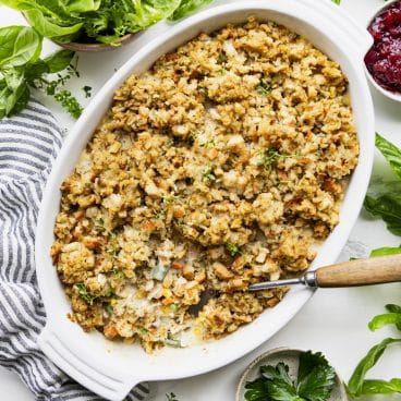 Square overhead image of a white dish full of turkey stuffing casserole.